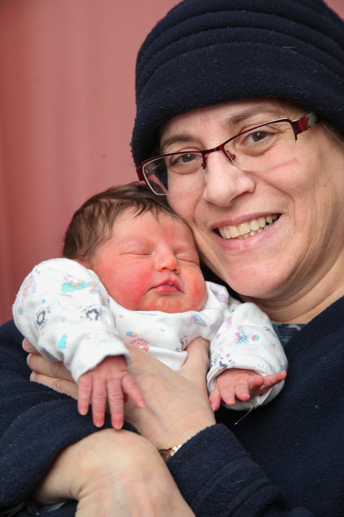 Chana Bracha Kornfeld with a newborn.